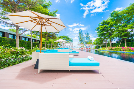 Umbrella and chair around swimming pool in beautiful luxury hotel resort for holiday vacation concept backgroundの写真素材