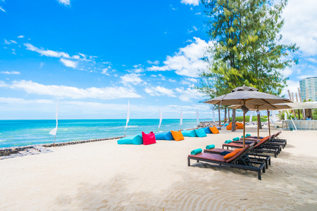 Outdoor with umbrella and chair on beautiful tropical beach and sea and blue sky background