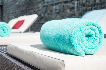 Pool towel on chair decoration around swimming pool in hotel resortの写真素材