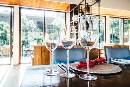 Selective focus point on Wine glass and table setting for dinner in luxury restaurant - Vintage...