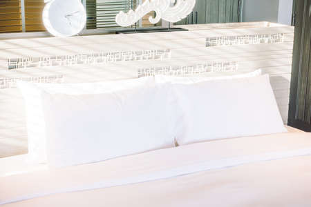 Beautiful white pillow on bed decoration in bedroom interior - Vintage light Filterの写真素材