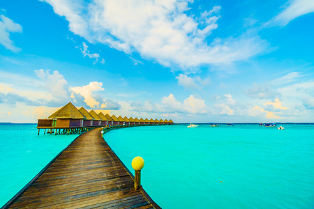 Beautiful tropical Maldives resort hotel and island with beach and sea on sky for holiday vacation background concept -Boost up color Processingの写真素材