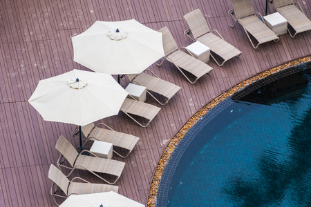 Umbrella and chair around beautiful luxury outdoor swimming pool in hotel resort