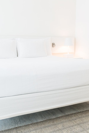 White pillow on bed with table light lamp decoration in bedroom interiorの写真素材