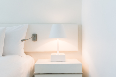 White pillow on bed with table light lamp decoration in bedroom interiorの写真素材