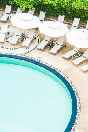 Outdoor swimming pool with umbrella and chair in hotel resortのeditorial素材