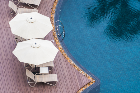Umbrella and chair around beautiful luxury outdoor swimming pool in hotel resortのeditorial素材