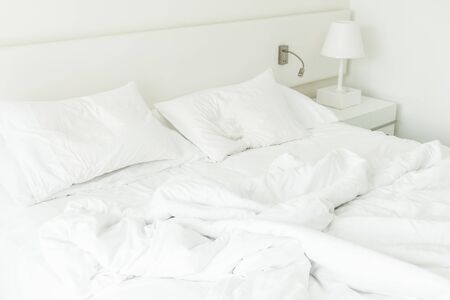 White pillow on rumpled bed decoration in bedroom interiorの写真素材