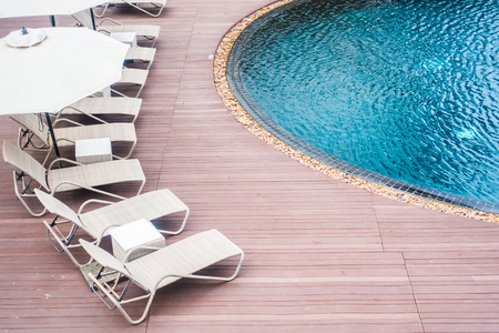 Umbrella and chair around beautiful luxury outdoor swimming pool in hotel resortのeditorial素材