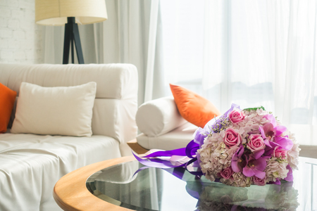 Bouquet flower with pillow on sofa decoration in living room interiorの写真素材