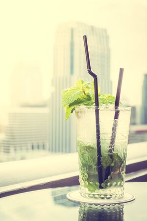 Mocktails glass on the top bar with city view background - Vintage Filter and Sunflare Processingの写真素材