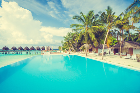 Beautiful luxury outdoor swimming pool with umbrella and chair in hotel resort at maldives - Boost up color and Filter effect Processingのeditorial素材