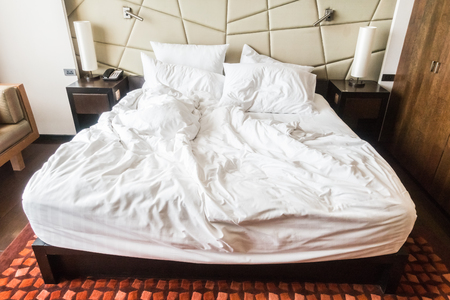 rumpled bed with white messy pillow decoration in bedroom interiorのeditorial素材