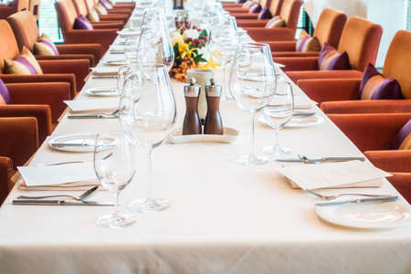 Selective focus point on wine glass with table setting for dining in restaurantの写真素材