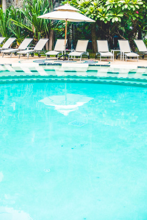 Beautiful outdoor swimming pool with umbrella and chair in hotel resortのeditorial素材