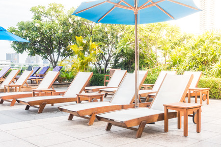 Umbrella and chair decoration around swimming pool  in hotel and resort - Sunflare effect