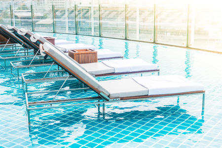 Beautiful luxury chair around swimming pool in hotel resort - Filter effect and sunflare Processing