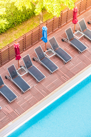 Umbrella and chair around outdoor swimming pool in beautiful luxury hotel and resort - Sunflare filterの写真素材