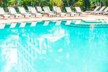 Beautiful outdoor swimming pool with umbrella and chair in hotel resortの写真素材