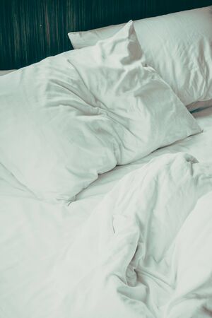 White sheet pillow on messy bed decoration in bedroom interior - Vintage Filter