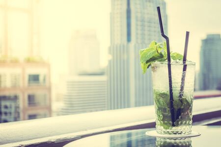 Mocktails glass on the top bar with city view background - Vintage Filter and Sunflare Processingの写真素材