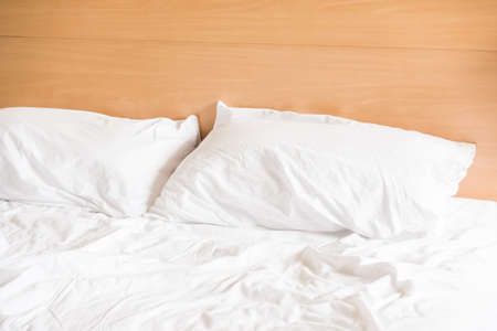 White messy pillow on sheet bed decoration in bedroom interiorの写真素材