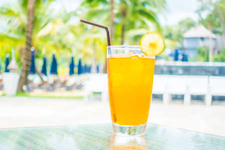 Orange juice glass with pool view backgroundの写真素材