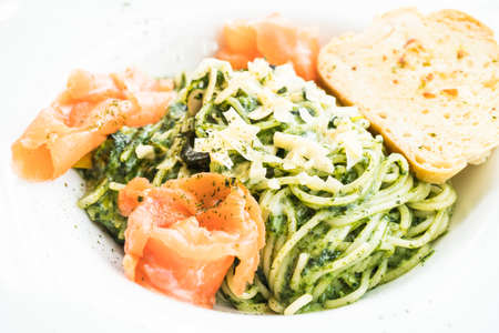 Spaghetti pesto with salmon meat in white plateの写真素材