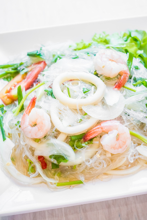Spicy salad with seafood in white plate with thai styleの写真素材