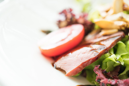 Selective focus point on Smoked duck salad with vegetable and sweet sauce in white plate - Healthy food styleの写真素材