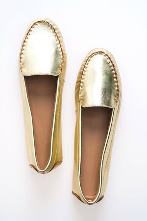 Beautiful luxury fashion woman shoes with golden color isolated on white backgroundの写真素材