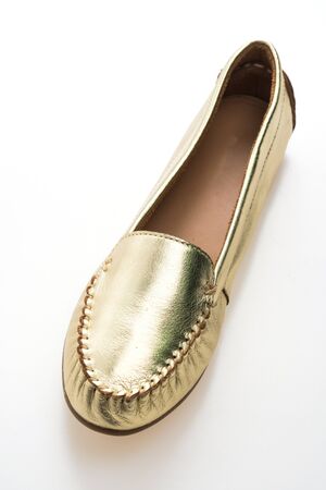 Beautiful luxury fashion woman shoes with golden color isolated on white backgroundの写真素材