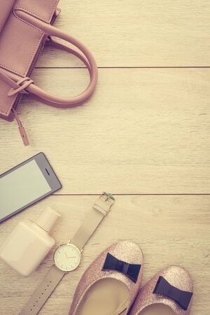 Beautiful casual woman fashion set with Pink Jacket Jeans Pants Handbag and Shoes on wood background with copy space - Vintage light Processingの写真素材