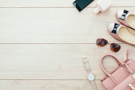 Beautiful casual woman fashion set with Pink Jacket Jeans Pants Handbag and Shoes on wood background with copy space - Vintage light Processingの写真素材