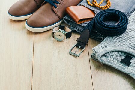 Beautiful men fashion with Sweater Jeans Belt Socks Wallet Watch and Brown leather shoes on wooden background - Vintage light filter Processingの写真素材