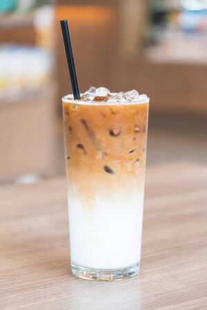 Iced latte coffee glass on wooden table in restaurant and cafeの写真素材