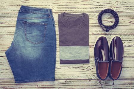 Men clothes set with T-shirt Jeans pants and shoes on wooden background - Vintage Filterの写真素材
