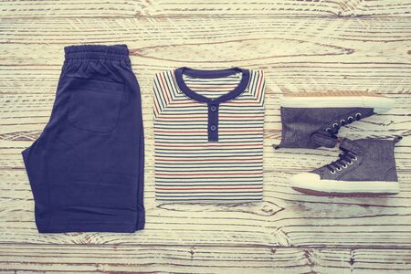 Men clothes set with T-shirt Jeans pants and shoes on wooden background - Vintage Filterの写真素材