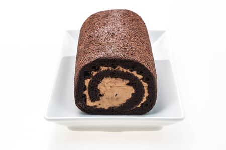 Chocolate roll cake in plate isolated on white backgroundの写真素材