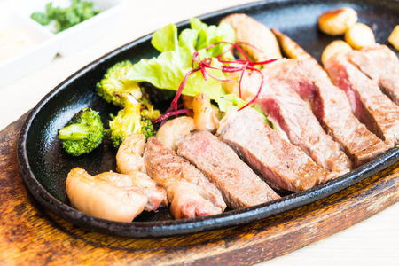 Grilled Beef steak with vegetable in black plateの写真素材