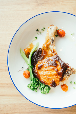 Grilled pork chop steak with vegetable in white plateの写真素材