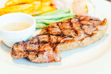 Grilled beef steak with vegetable in white plateの写真素材