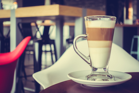 Coffee cup on wood table with restaurant and bar background - Vintage filter Processingの写真素材