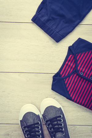 T-shirt with pants and shoes on wooden background - Vintage Filterの写真素材