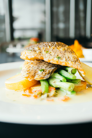 Steak fish meat with vegetable in white plate