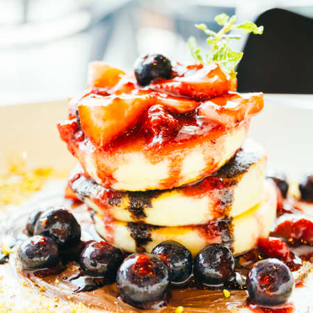 Sweet dessert Pancakes with mixed berry fruit in white plateの写真素材