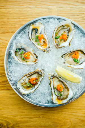 Raw and fresh oyster shell with lemon on iceの写真素材