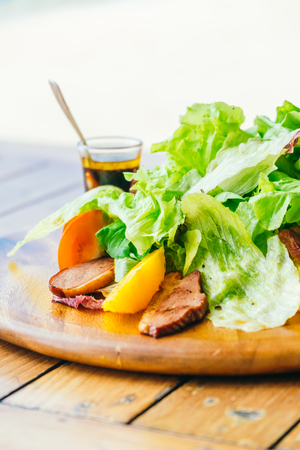 Grilled Duck breast with vegetable salad on wooden plateの写真素材