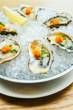 Raw and fresh oyster shell with lemon on iceの写真素材