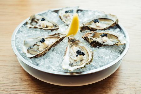 Raw and fresh Oyster with caviar on top and lemon on plate - Color Filter Processingの写真素材